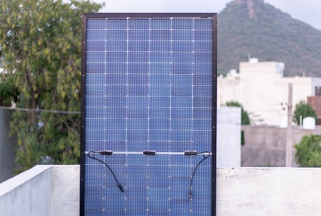 Bifacial solar panel leaning on a wall