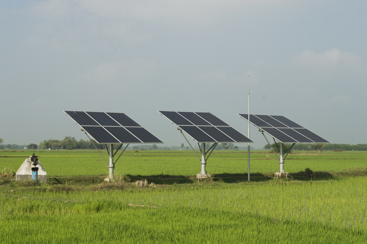 Solar panels with pump in green farm field