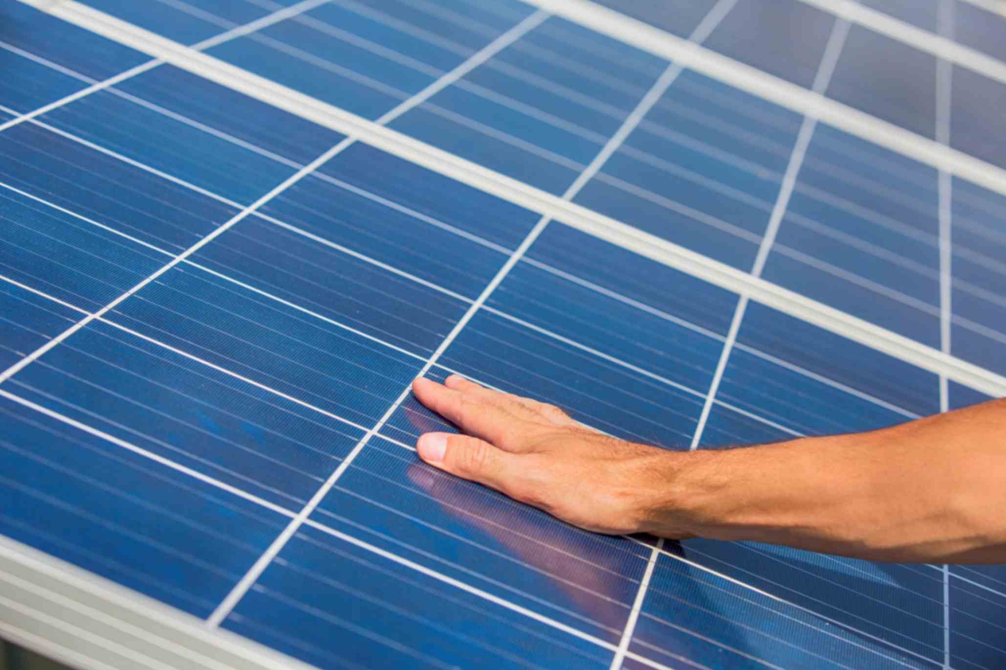 man placed hand on solar panel to debunk myths about solar power system